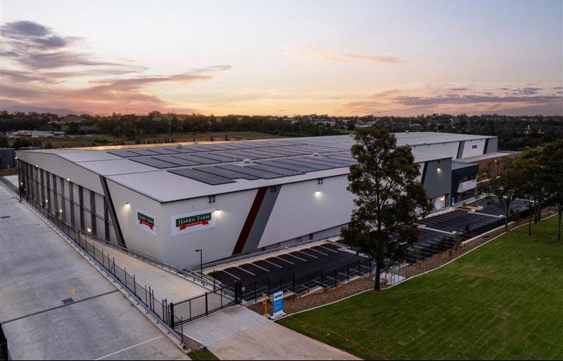 Large industrial building with solar panels at sunset